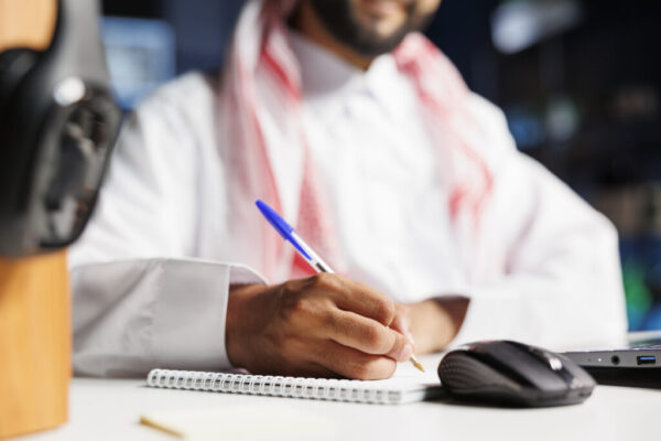 Muslim guy writing down research notes